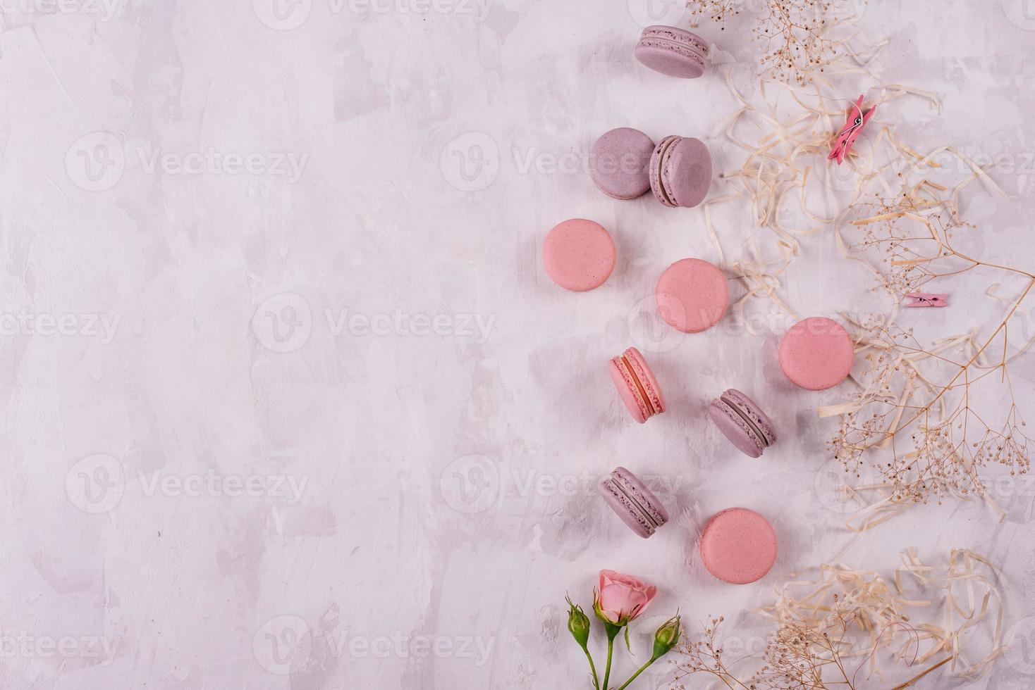 lindos macaroons saborosos cor de rosa em um fundo de concreto foto