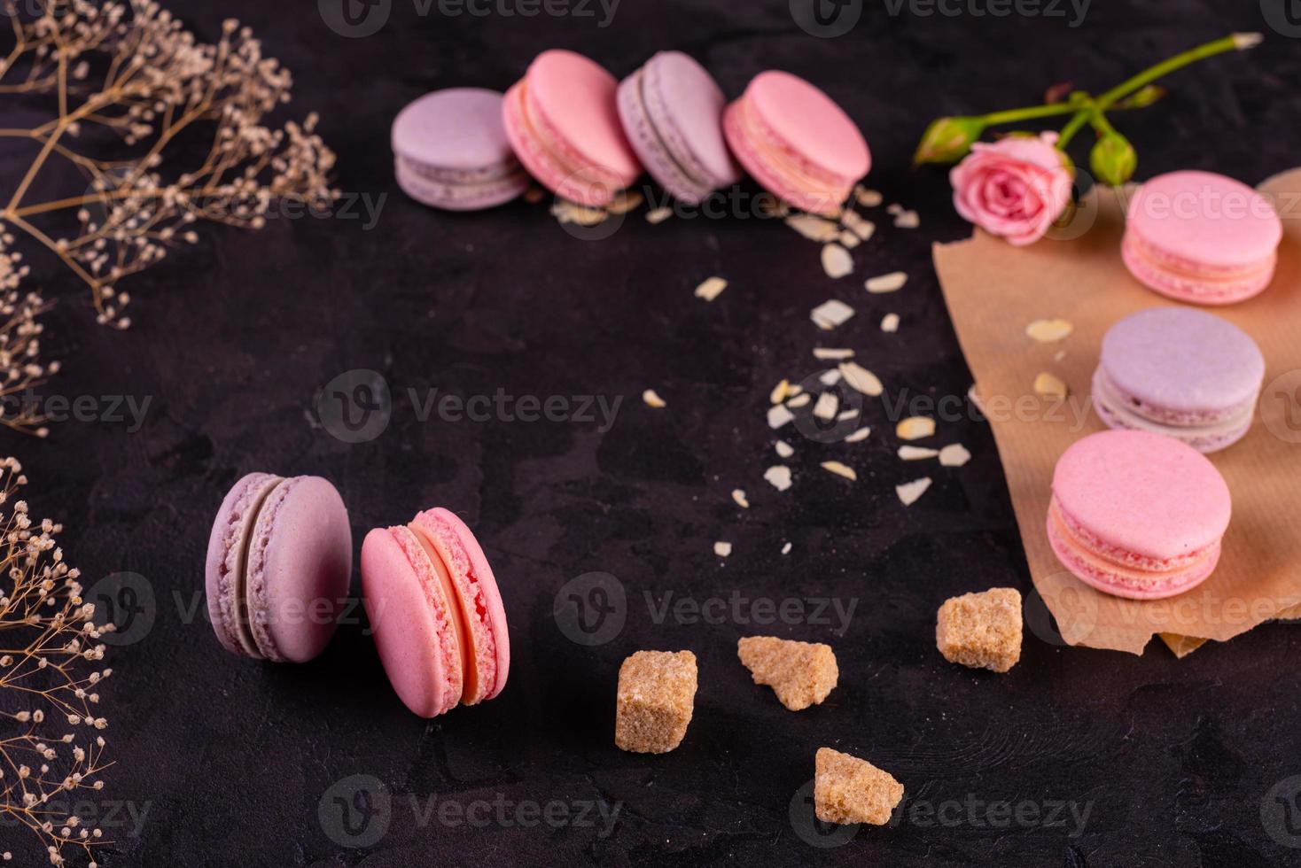 lindos macaroons saborosos cor de rosa em um fundo de concreto foto