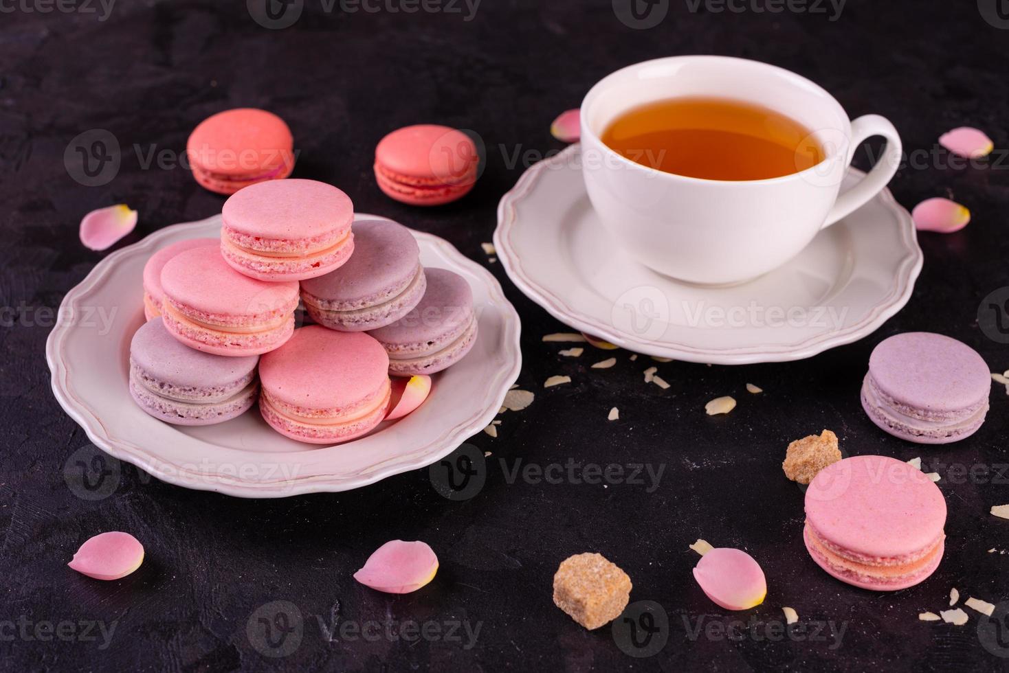 lindos macaroons saborosos cor de rosa em um fundo de concreto foto