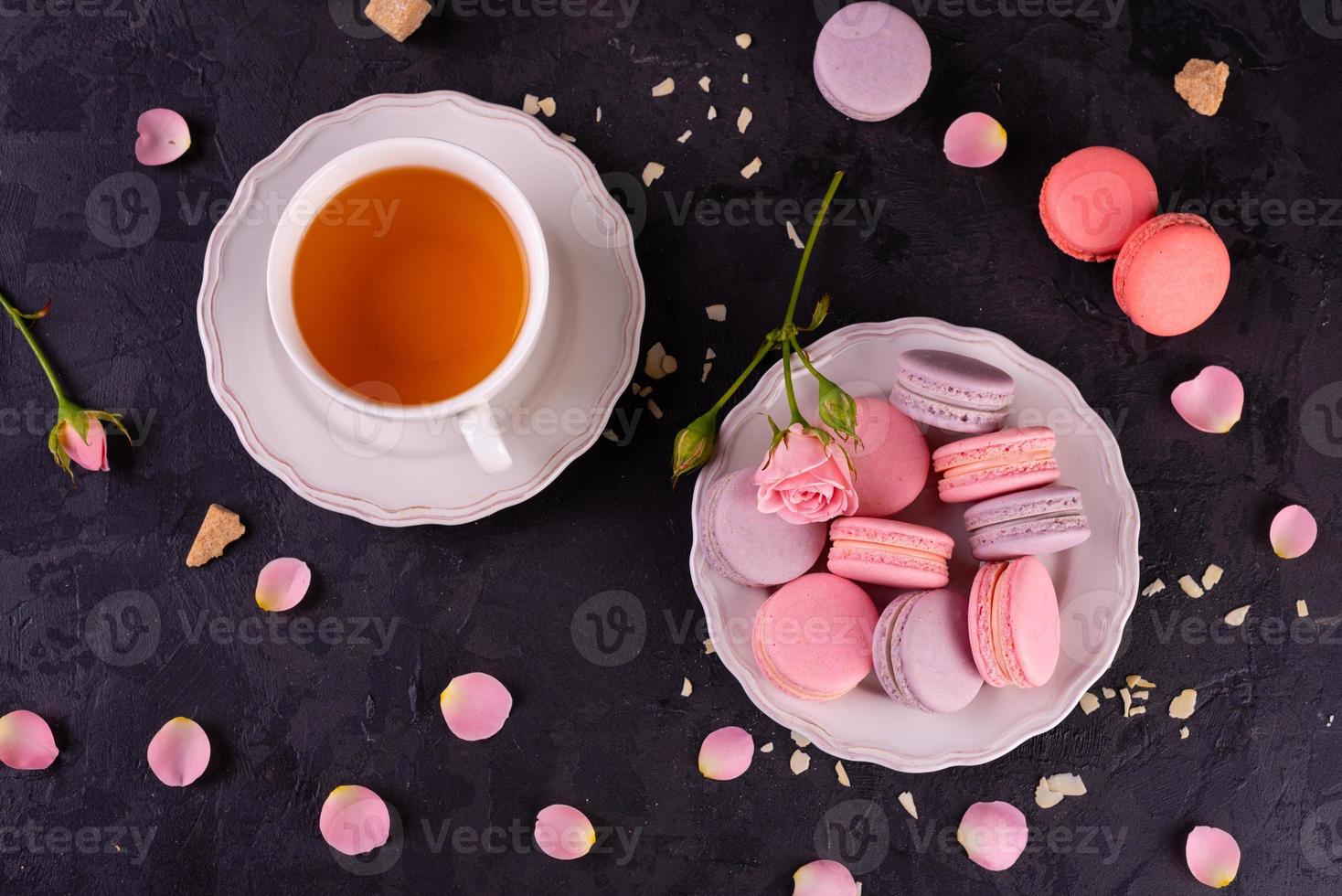 lindos macaroons saborosos cor de rosa em um fundo de concreto foto