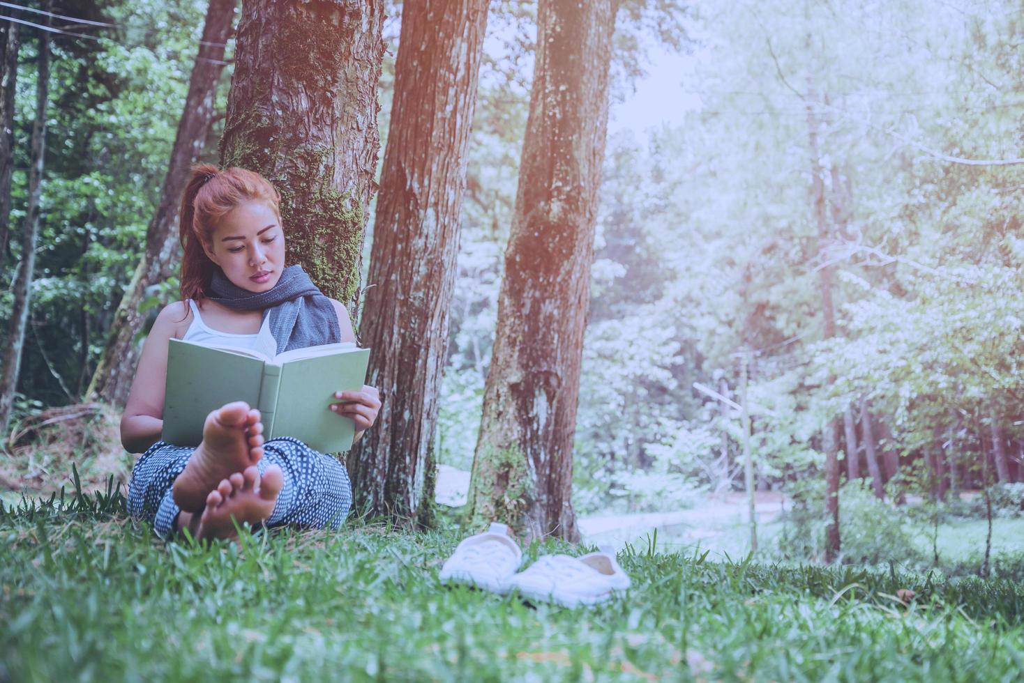 mulher relaxante lendo no parque. feriado foto