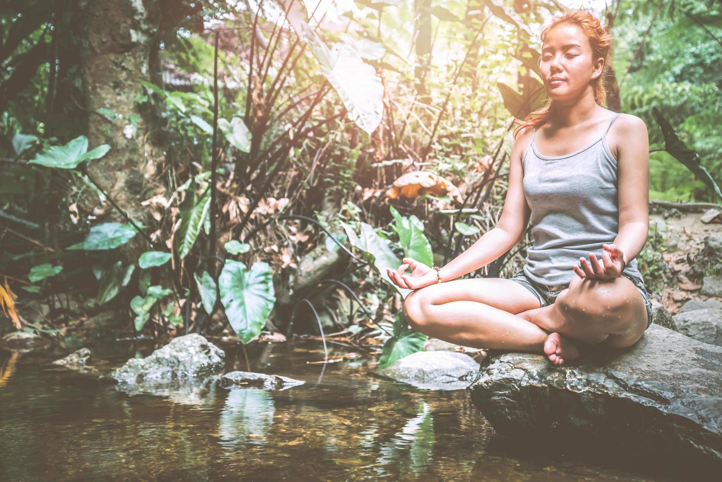 mulher Ásia viajantes viajam natureza floresta cachoeira. medite em ioga foto