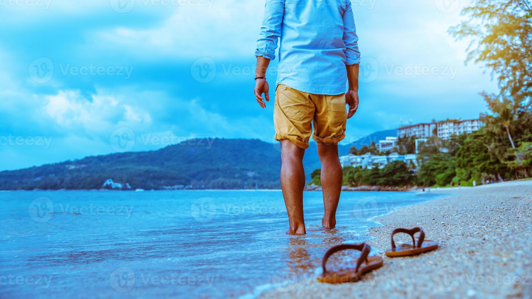 homem asiático viajar natureza. viajar relaxar. Caminhando na praia. no verão foto