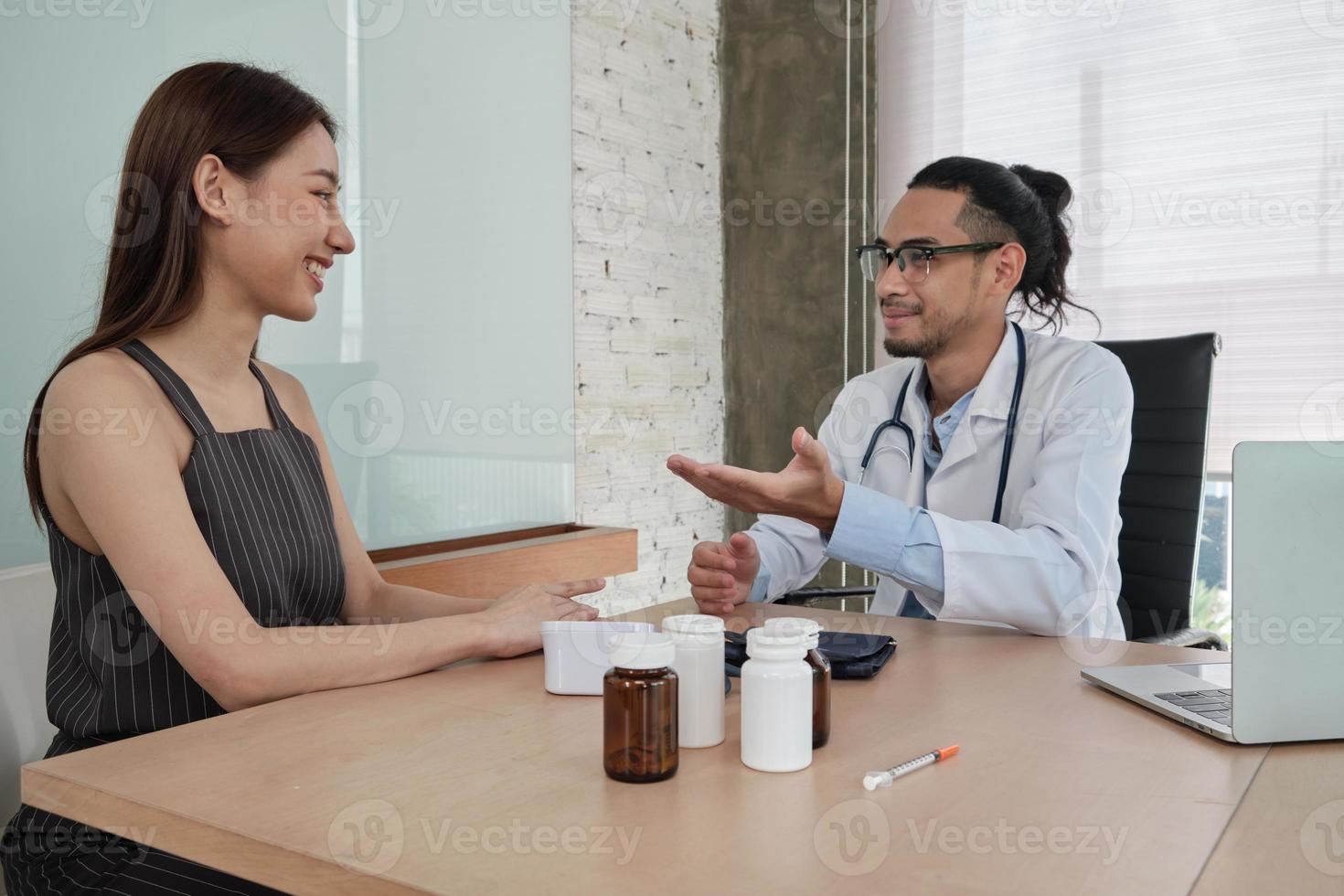 tratamento médico e check-up, jovem médico fala com um sorriso e examina uma paciente de etnia asiática durante uma consulta de saúde, aconselhamento em uma clínica de hospital. foto