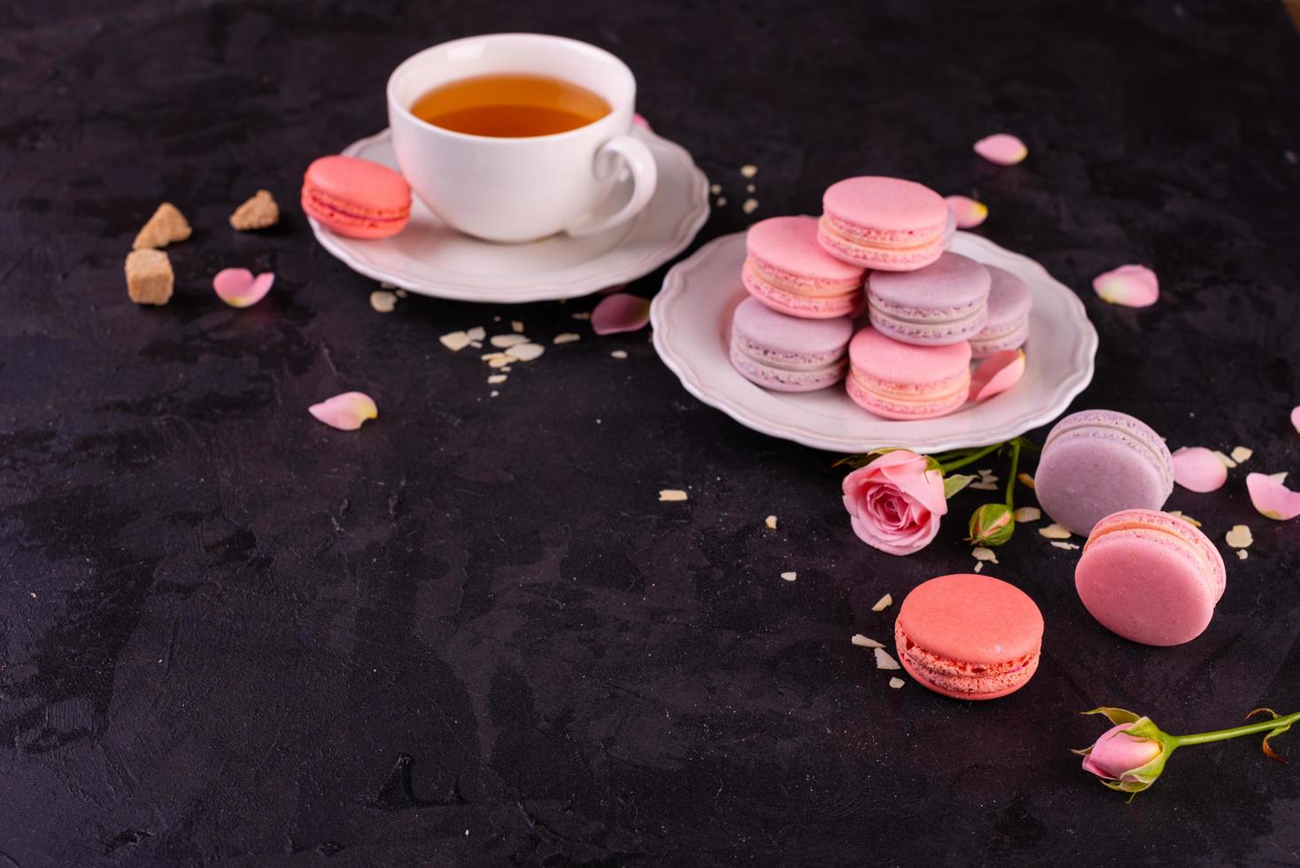 lindos macaroons saborosos cor de rosa em um fundo de concreto foto