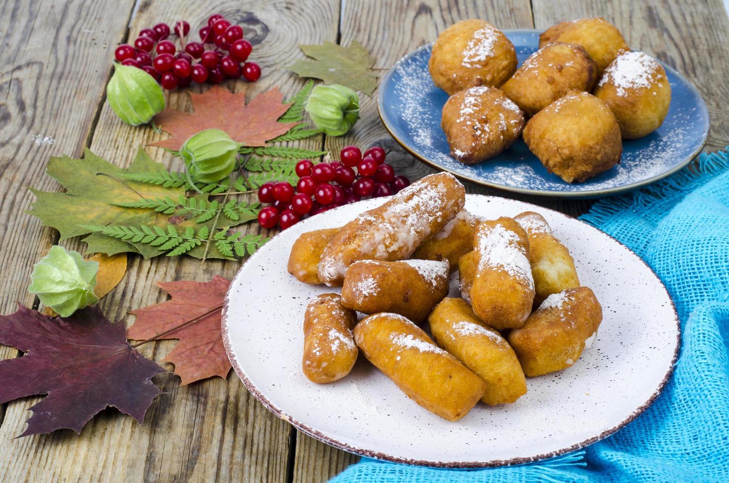 Pãezinhos de rosquinhas de coalhada doce com açúcar de confeiteiro na mesa de madeira foto