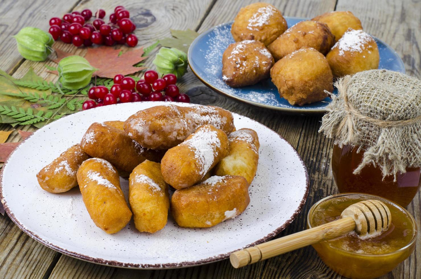 Pãezinhos de rosquinhas de coalhada doce com açúcar de confeiteiro na mesa de madeira foto