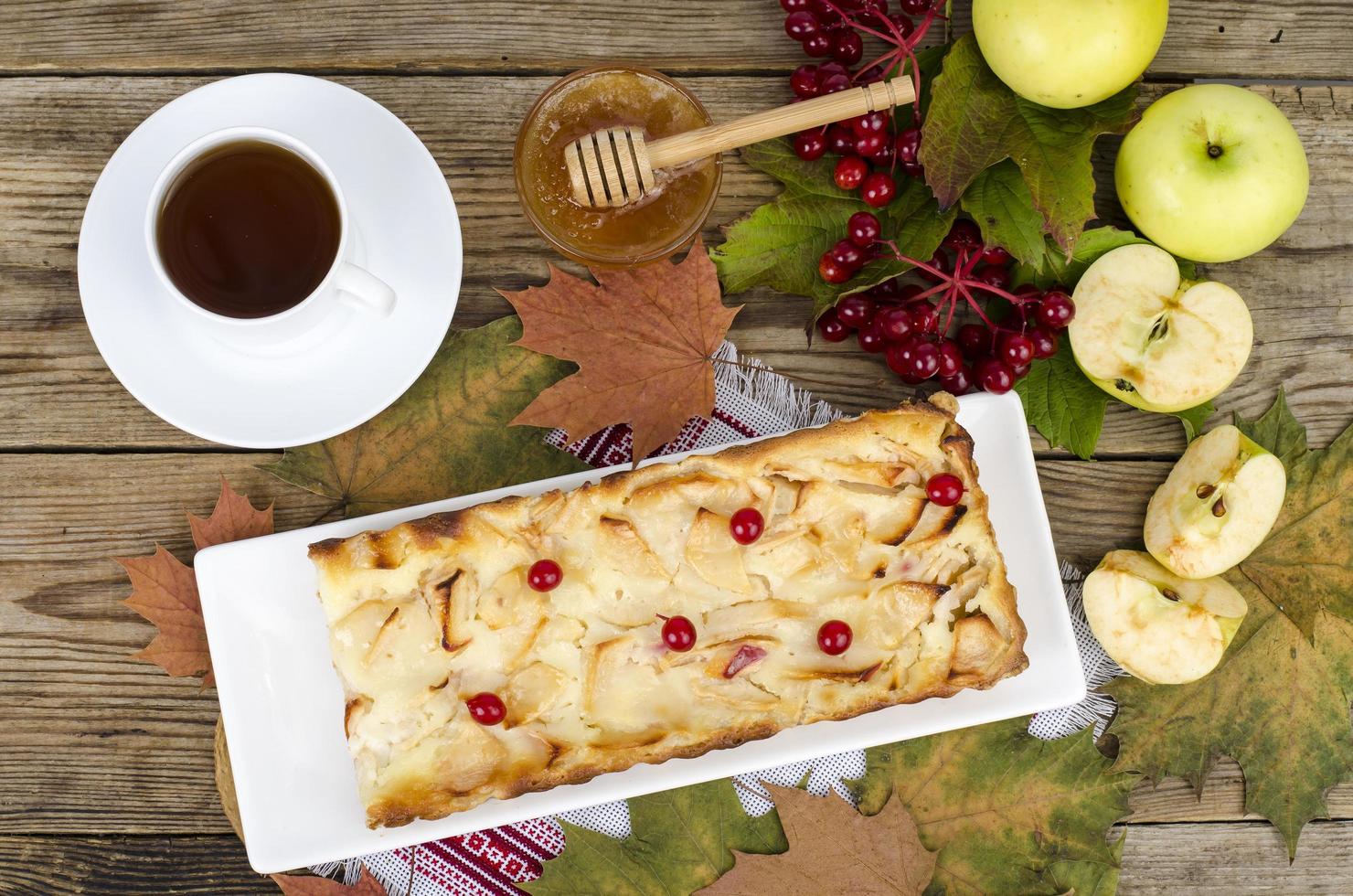 torta de maçã de outono com bagas de viburnum em fundo de madeira foto