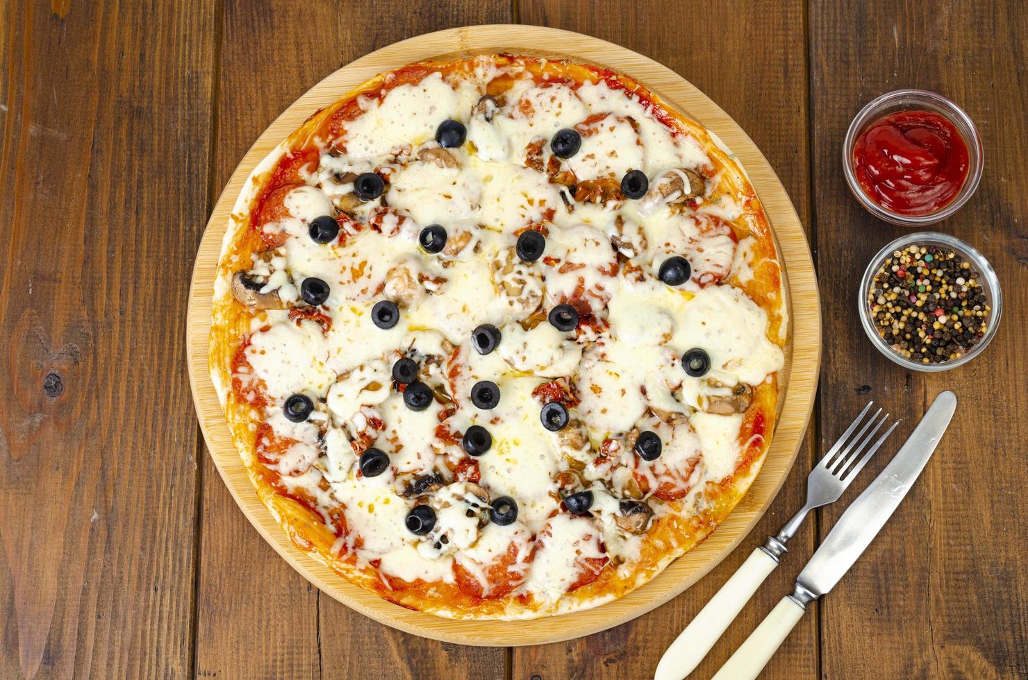 pizza caseira com calabresa, cogumelos, mussarela e azeitonas. foto de estúdio