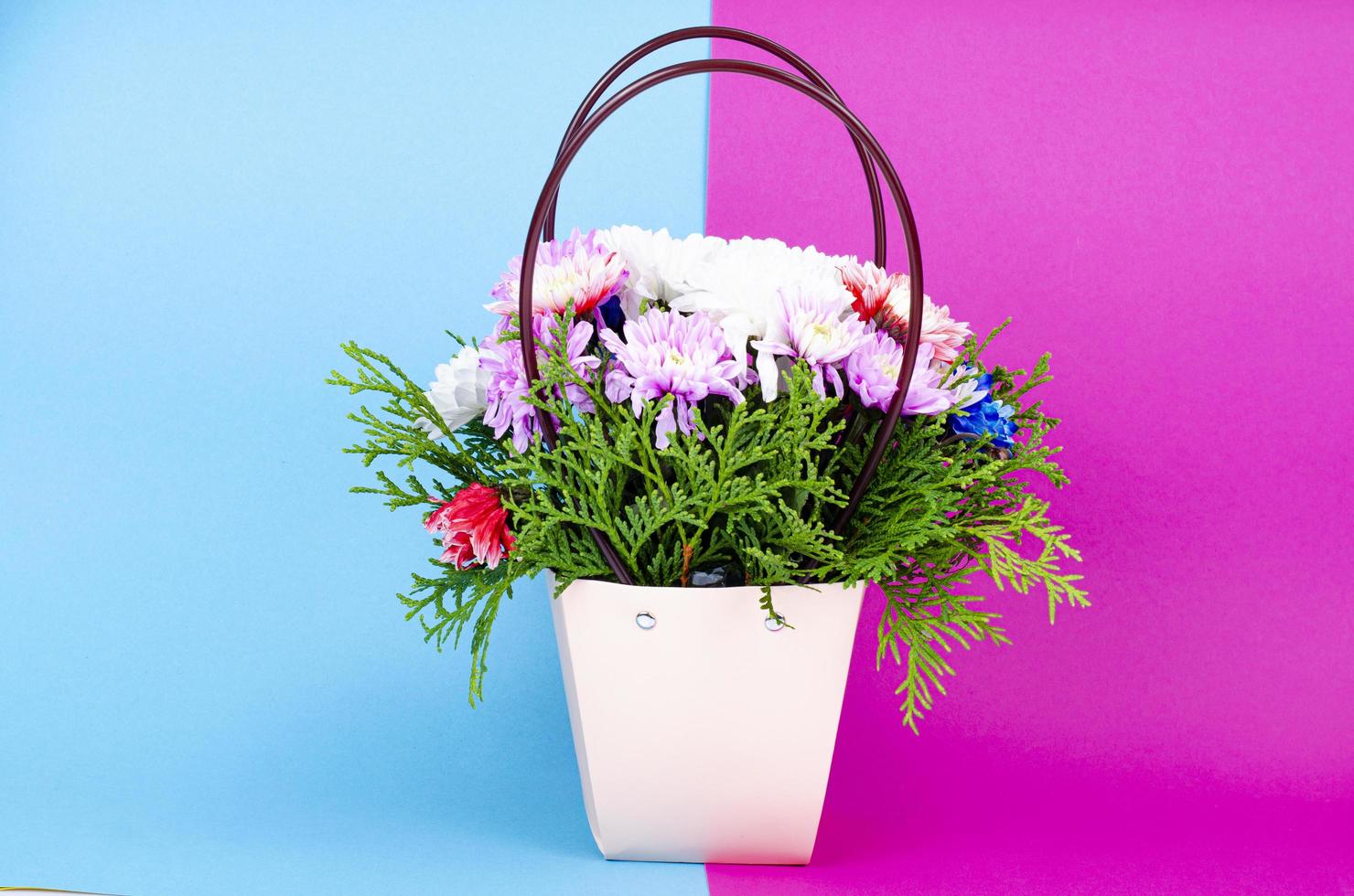 flores decorativas de crisântemo na cesta em fundo colorido. foto de estúdio.