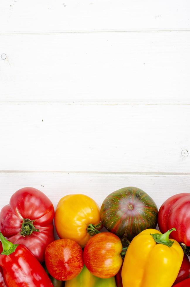 pimentão multicolorido e tomate na mesa de madeira. foto de estúdio.