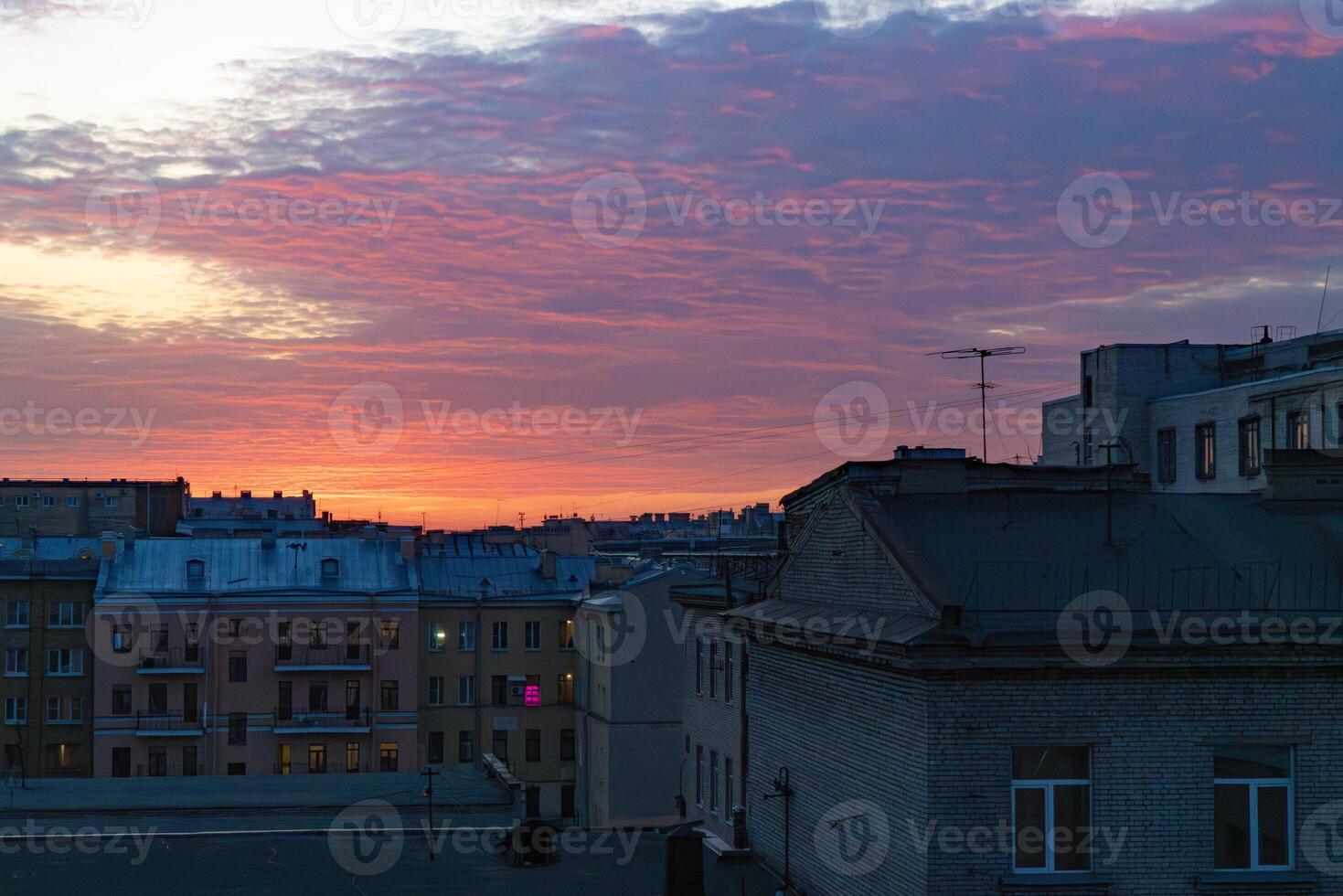 vívido primavera pôr do sol sobre santo petersburgo, com dramático nuvens e caloroso matizes refletindo fora a cidade edifícios foto