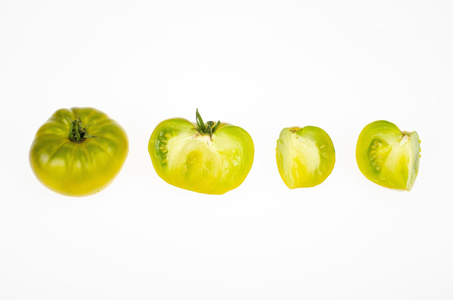 frutas inteiras e fatias de cor verde-amarelo de frutos de tomate maduro, isolados no fundo branco. foto de estúdio.