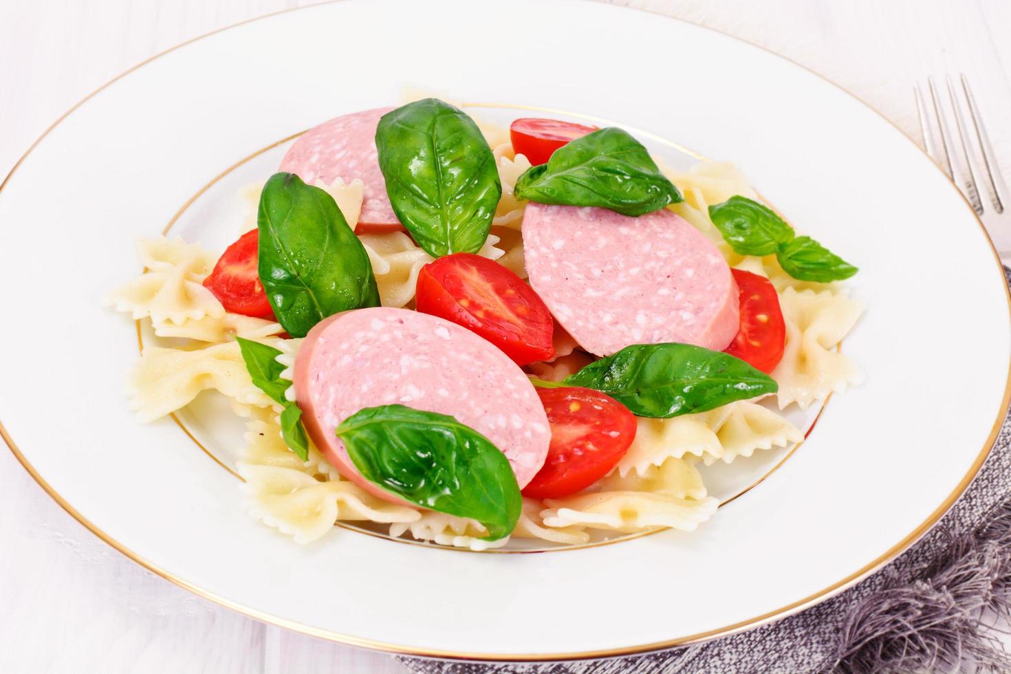 macarrão com cenoura em cubos, salame e ervilhas verdes foto