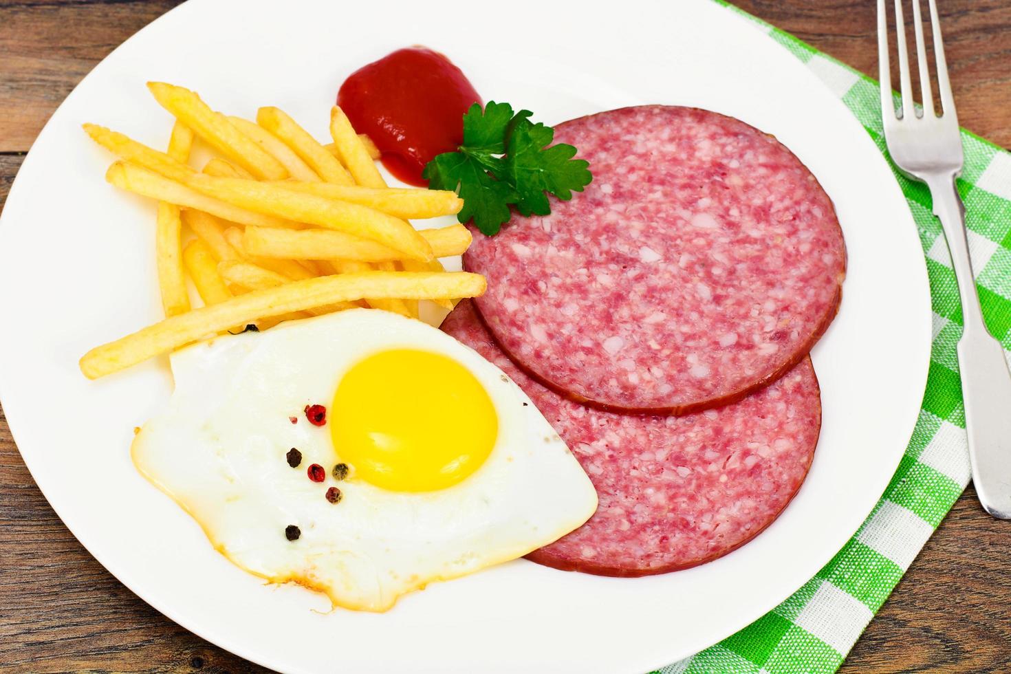 Batatas fritas com ovos mexidos, presunto, ketchup foto