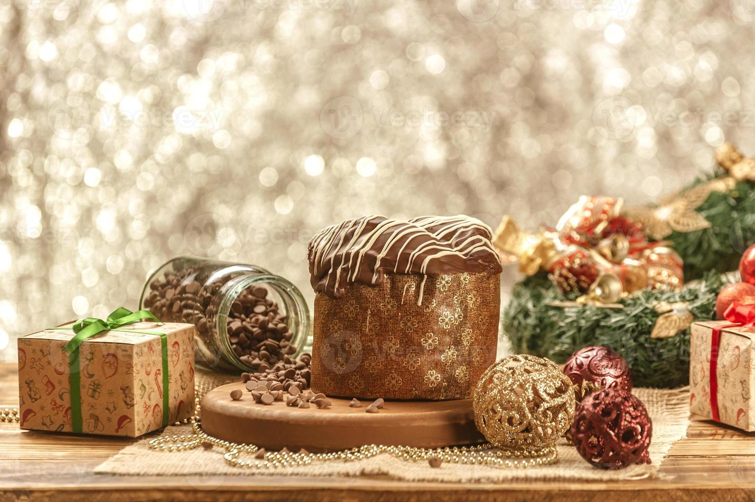 panetone de chocolate na mesa de madeira com enfeites de natal foto