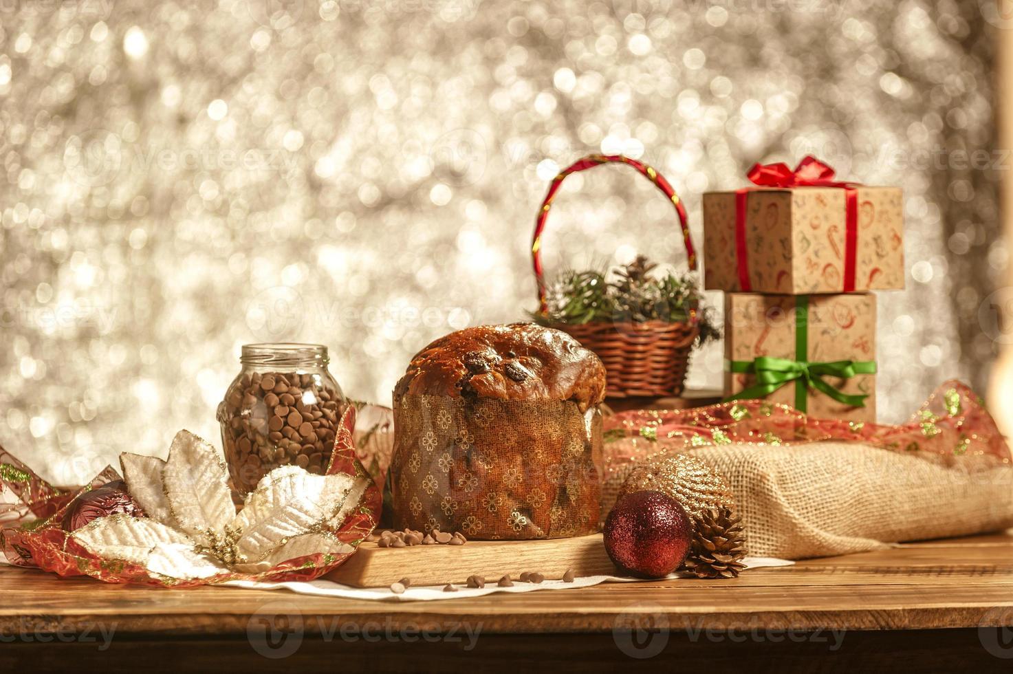 panetone de chocolate na mesa de madeira com enfeites de natal foto