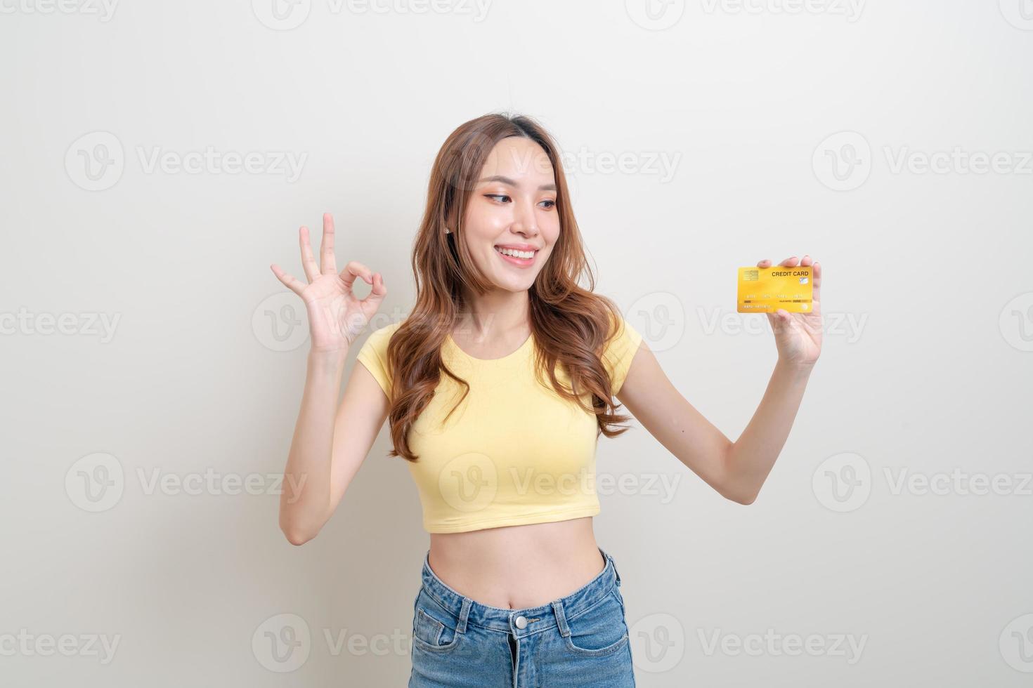 retrato linda mulher asiática segurando um cartão de crédito foto