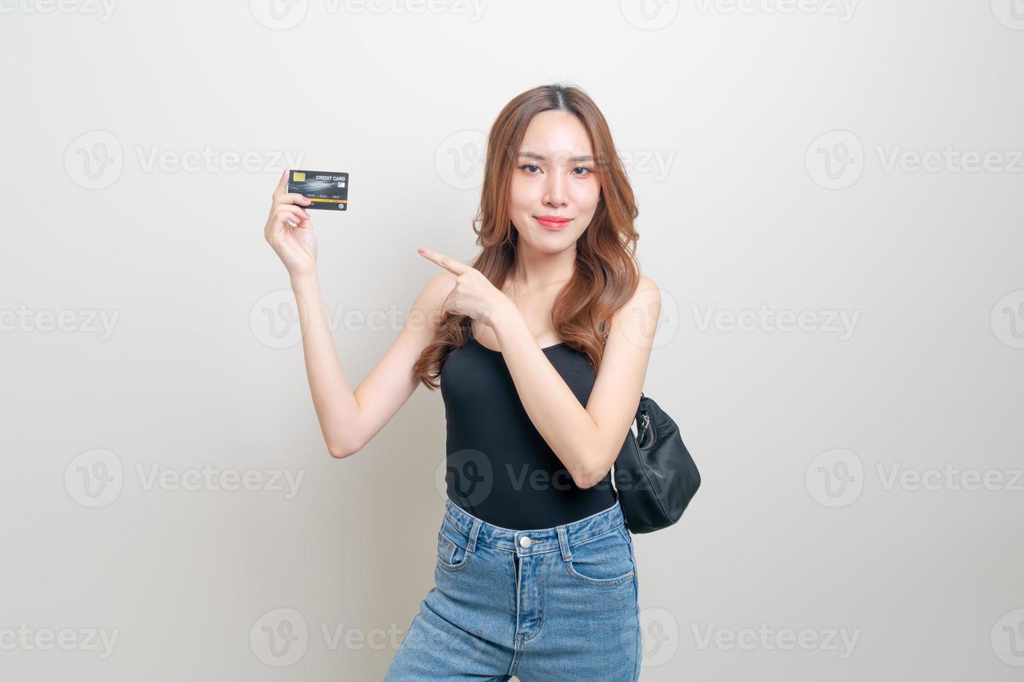 retrato linda mulher asiática segurando um cartão de crédito foto