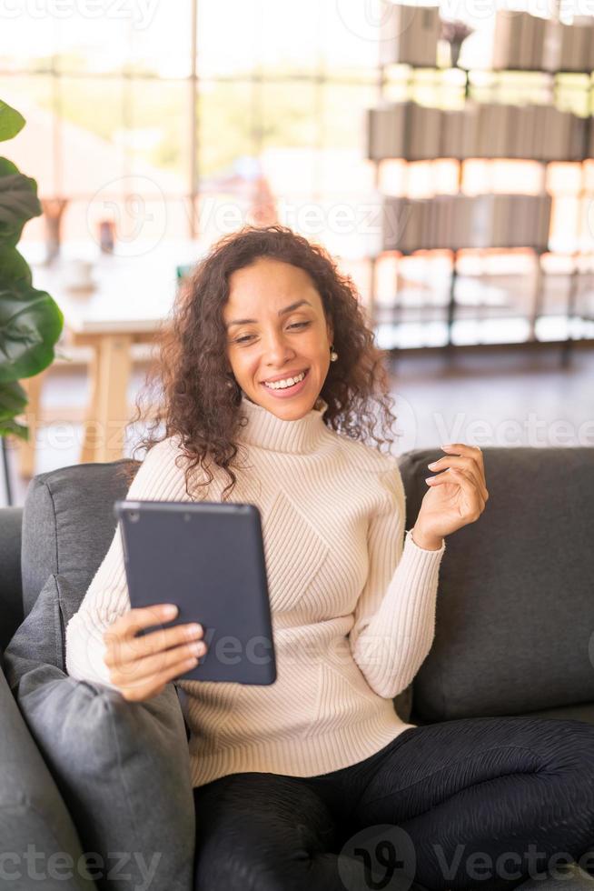 mulher latina videoconferência em tablet com sentimento de felicidade foto