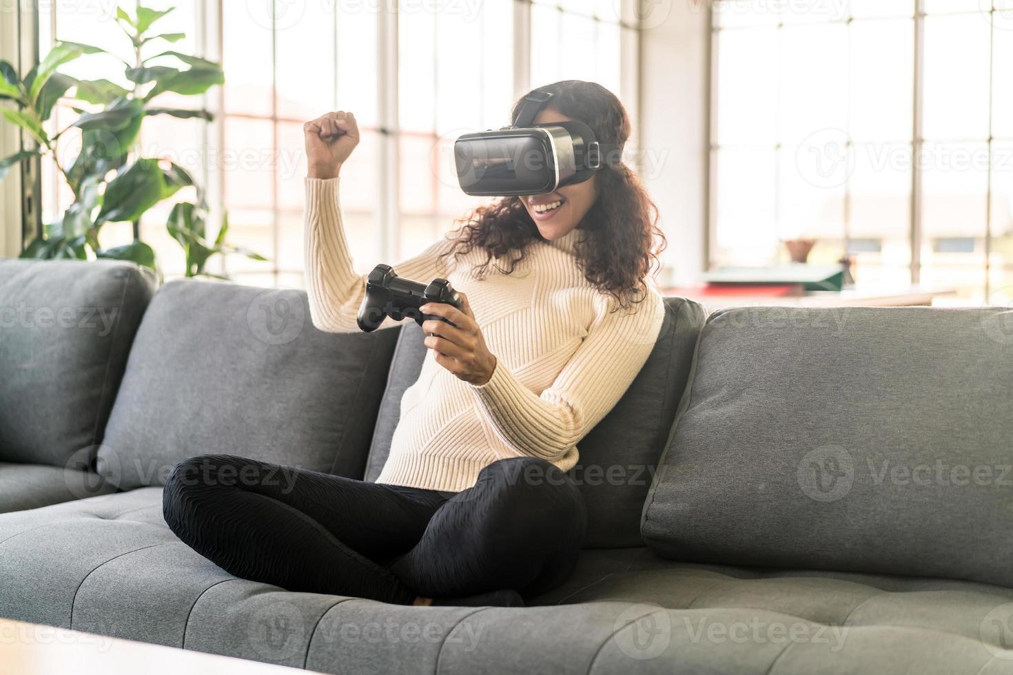 mulher latina usando um fone de ouvido de realidade virtual no sofá foto