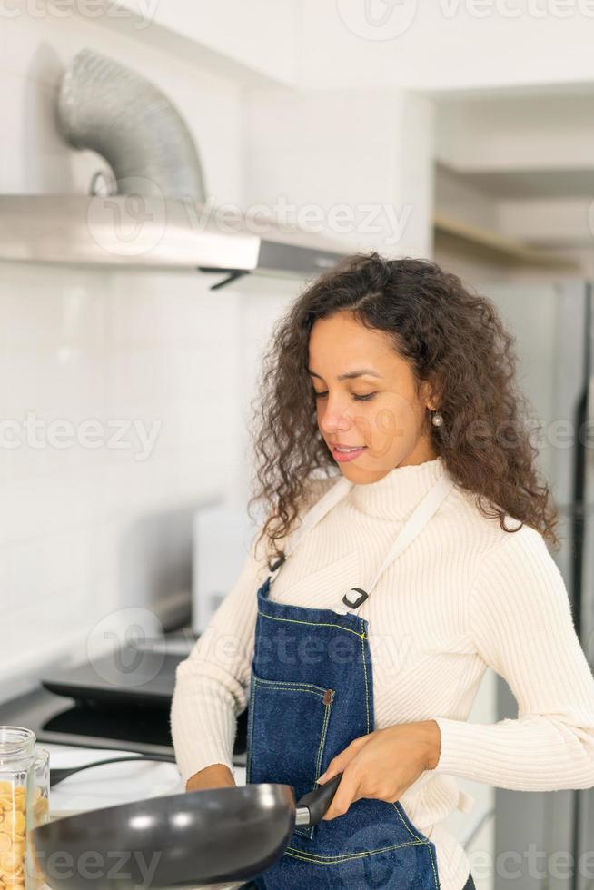 mulher latina cozinhando na cozinha foto