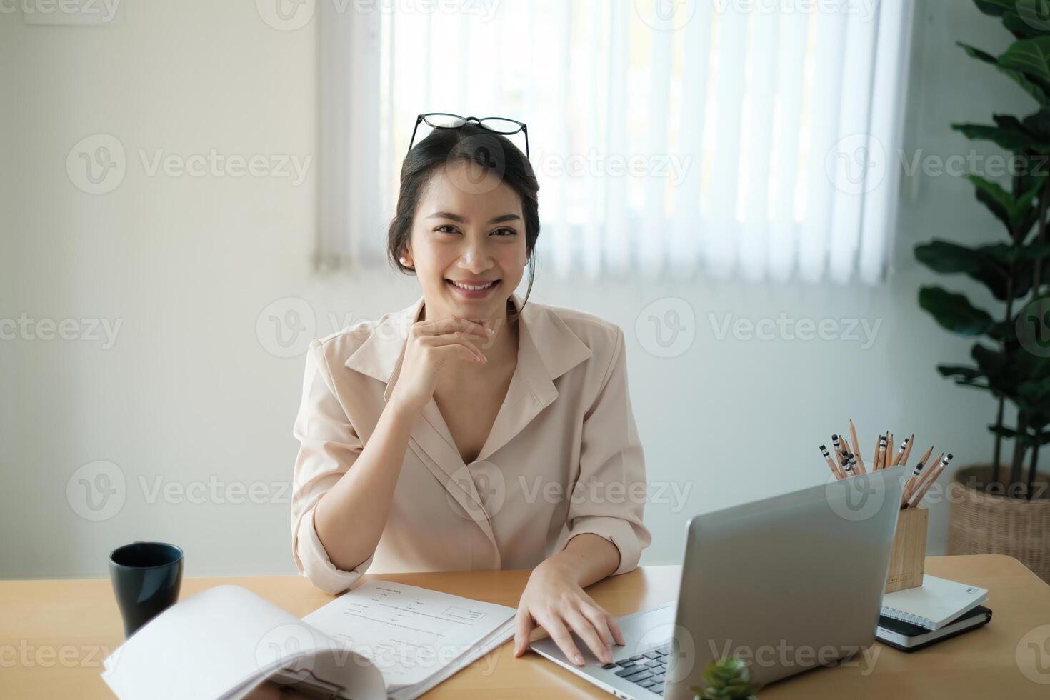 retrato do feliz mulher sentado às dela escritório. atraente jovem confiante o negócio mulher ou contador sorridente e ter idéia para dela grande projeto. foto