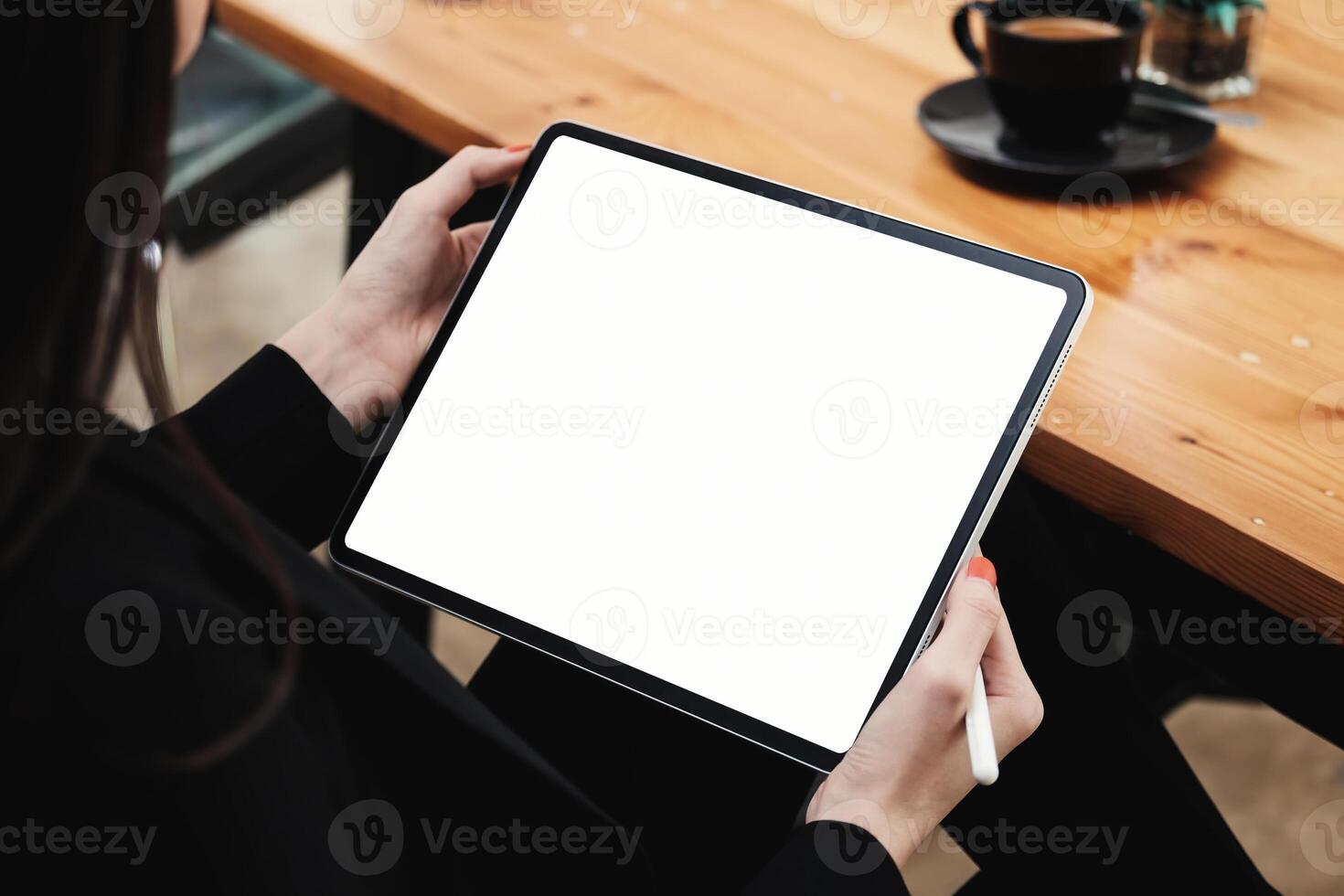 o negócio mulher segurando digital tábua e caneta lápis às cafeteria foto