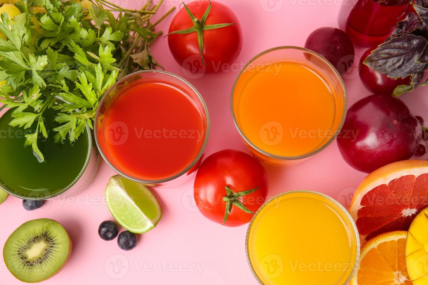 copos com suco saudável, frutas e vegetais na cor de fundo foto