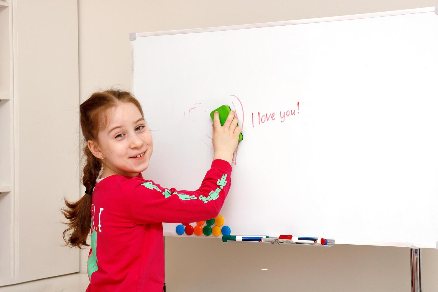 fofa pequeno menina apaga a inscrição Eu amor você a partir de a borda foto