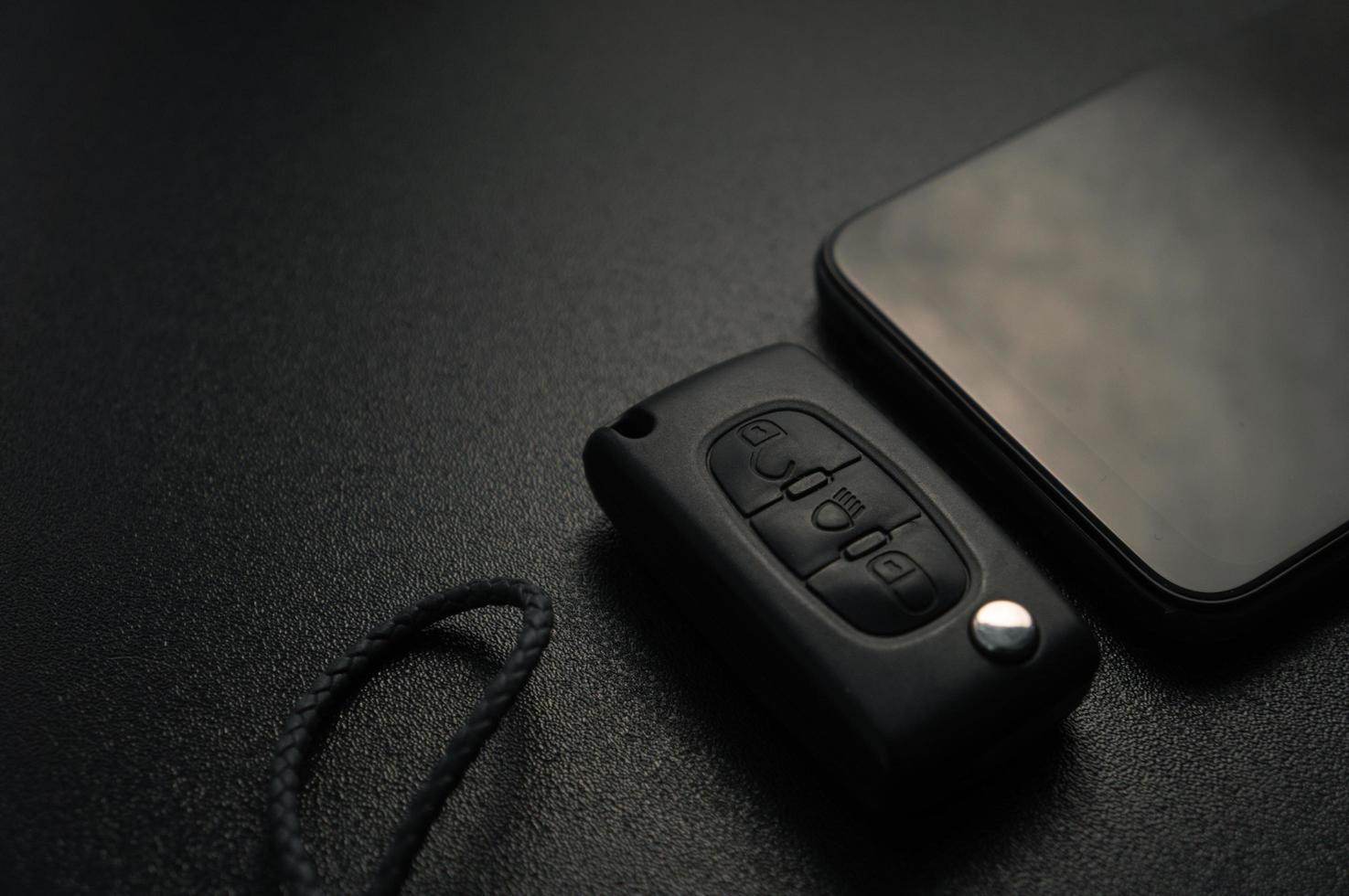 porta-chaves do carro e smartphone em um painel preto foto