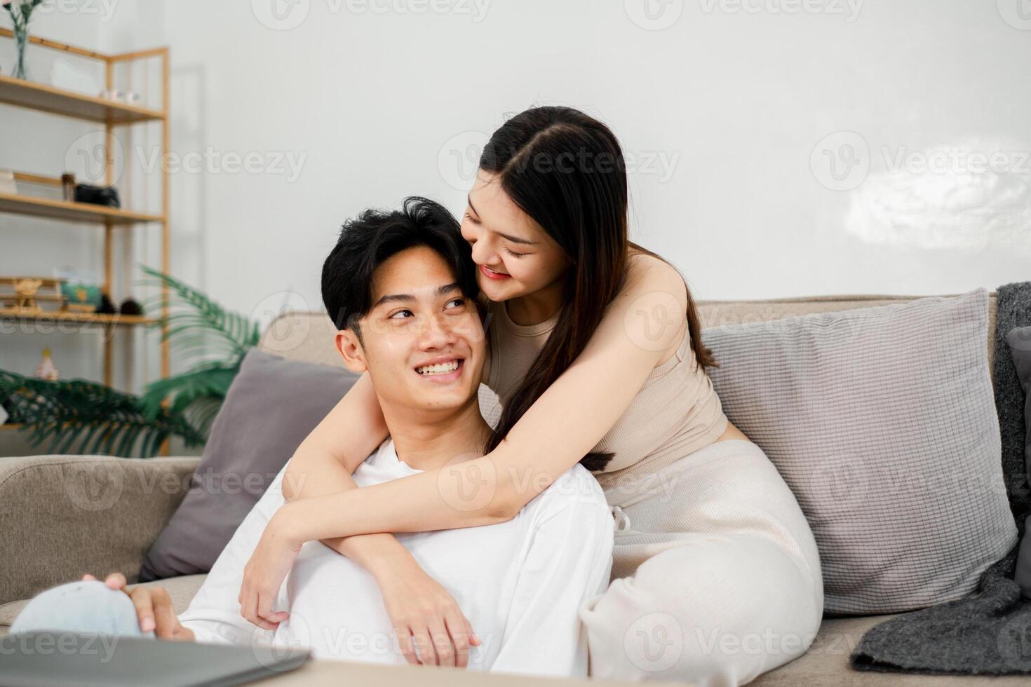 jovem homem sorrisos Como ele é calorosamente abraçado a partir de atrás de dele parceiro, refletindo uma espontâneo momento do alegria e proximidade. foto