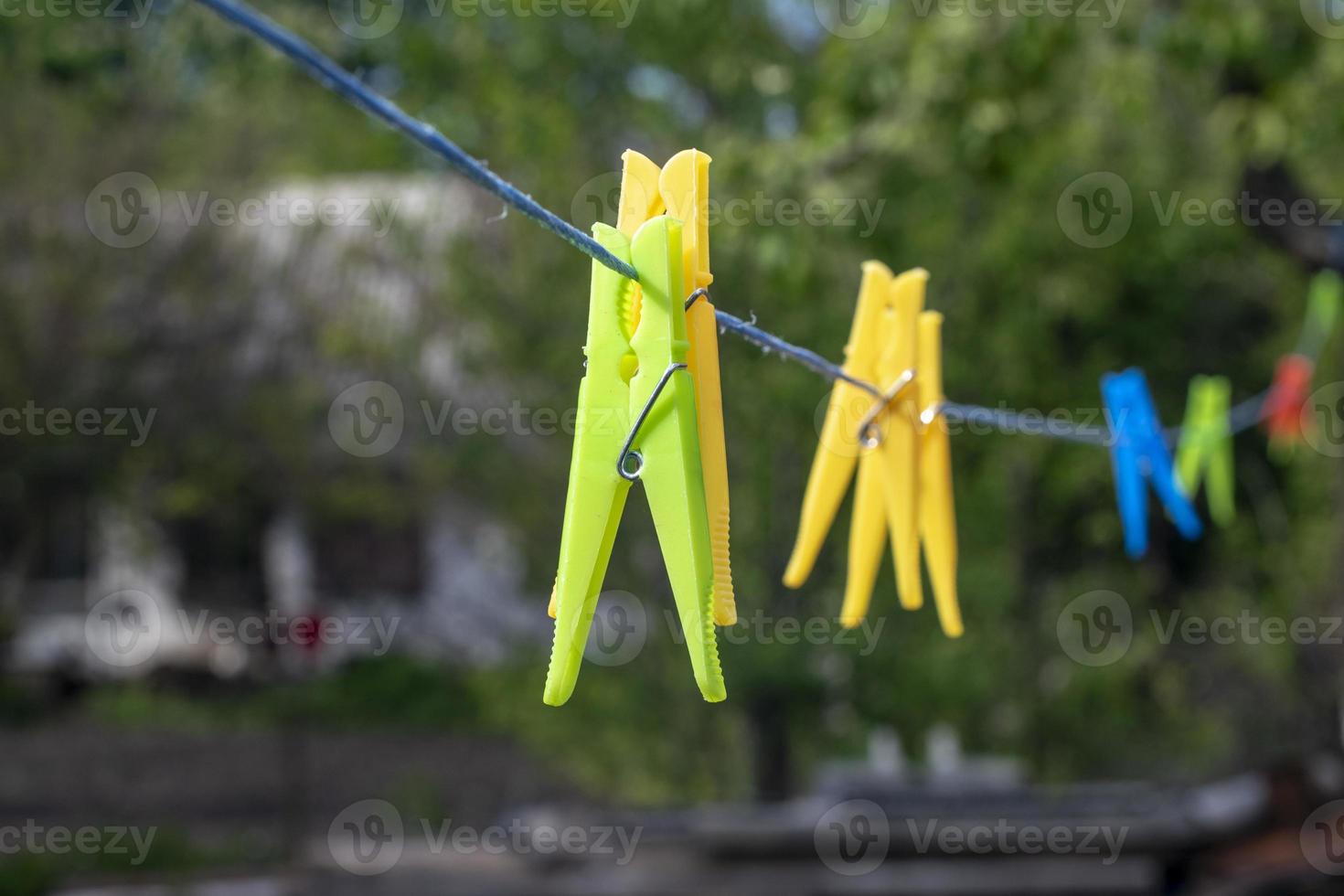 alfinetes de roupa de plástico prendedores de roupa de plástico coloridos pendurados em uma linha em uma corda. foto