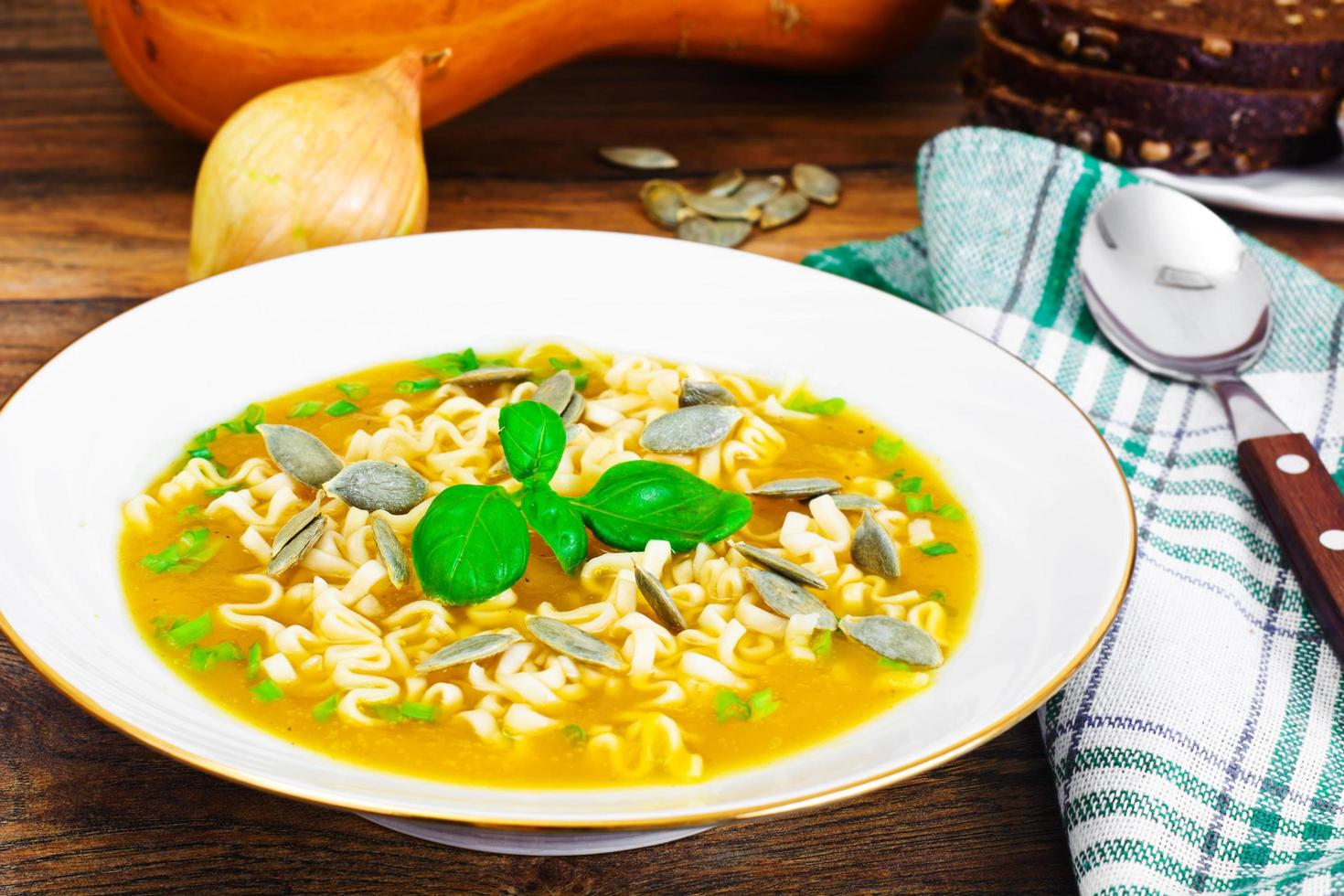 sopa de abóbora com macarrão, verduras e sementes de abóbora foto