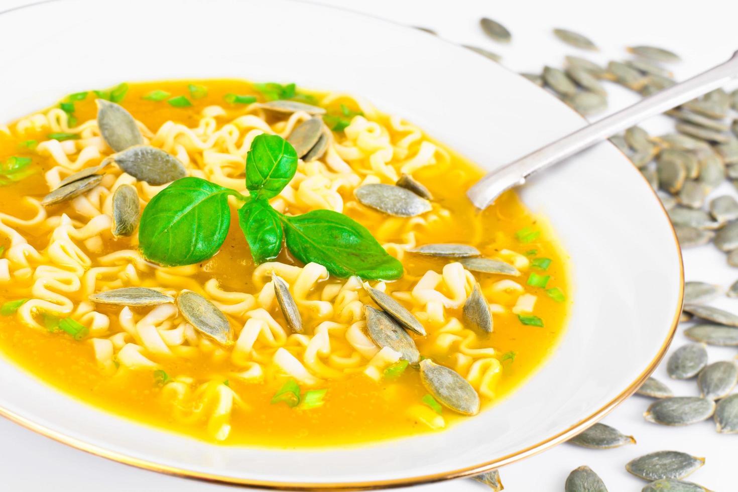 sopa de abóbora com macarrão, verduras e sementes de abóbora foto