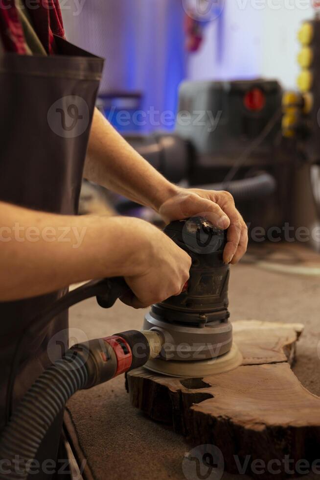 fabricante usando ângulo moedor em madeira serrada quadra para suave superfícies de abrasão com lixa. homem usando orbital lixadeira engrenagem para mobília montagem trabalho dentro montagem fazer compras foto