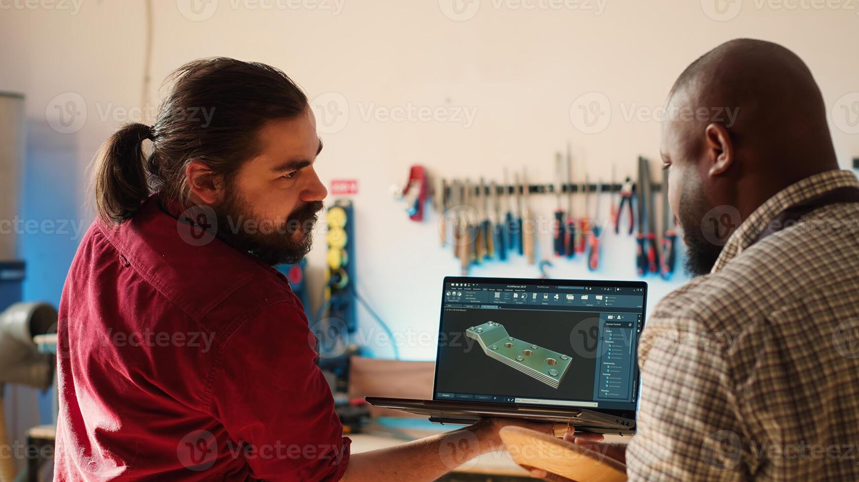 marceneiro olhando sobre plantas em computador portátil dentro cafajeste Programas com Aprendiz. fabricante e colega de trabalho concepção personalizadas 3d mobília em caderno dentro estúdio, preparando para cliente ordem, Câmera uma foto