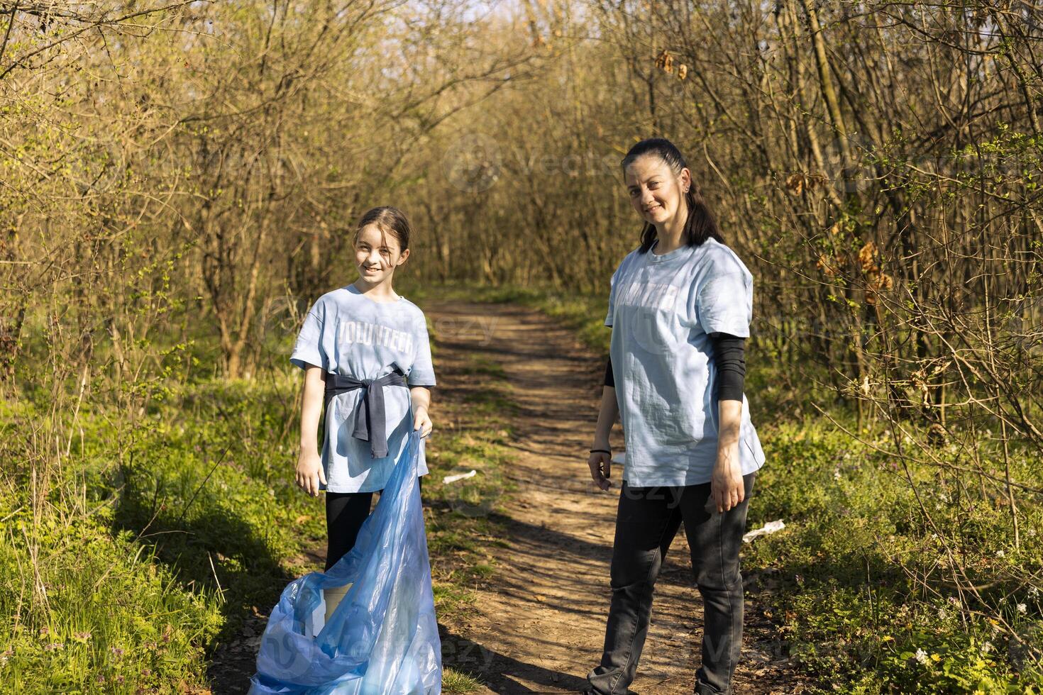 orgulhoso mãe e filha voluntariado para luta poluição, restaurando natural meio Ambiente e ajudando com ilegal despejo. pequeno criança reciclando plástico desperdício dentro uma disposição bolsa. foto