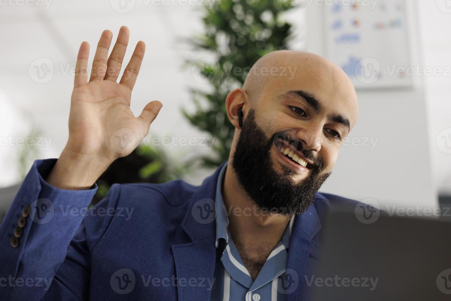 sorridente empreendedor atendendo controlo remoto conferência ligar e cumprimento funcionários. árabe executivo Gerente acenando Olá para equipe durante virtual conferência para discutir projeto foto