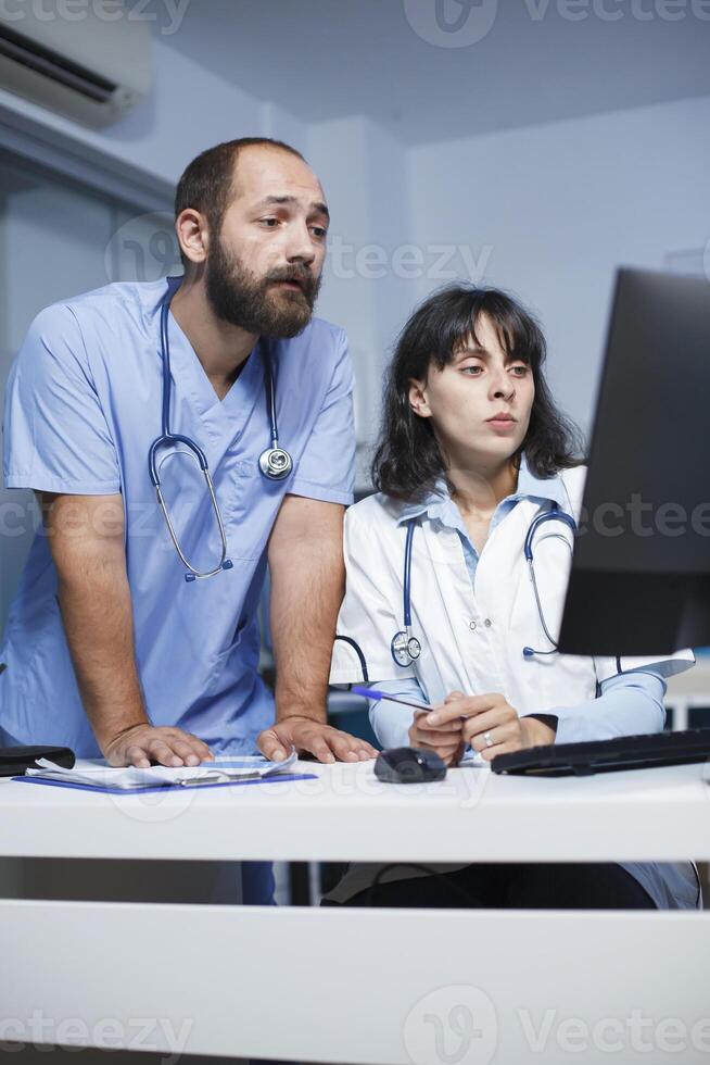 cuidados de saúde profissionais colaborar dentro uma hospital, discutindo paciente Cuidado, utilizando digital dispositivos gostar Área de Trabalho computadores. eficaz comunicação e trabalho em equipe estão destacado. foto