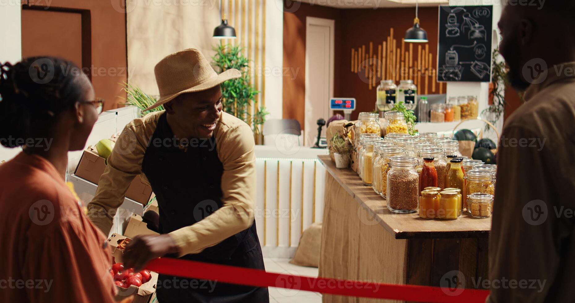 local comerciante abertura mercearia loja portas e acolhedor clientes, cumprimento pessoas com Novo orgânico caseiro frutas e legumes. africano americano fornecedor vendendo eco amigáveis Comida Unid. Câmera 2. foto