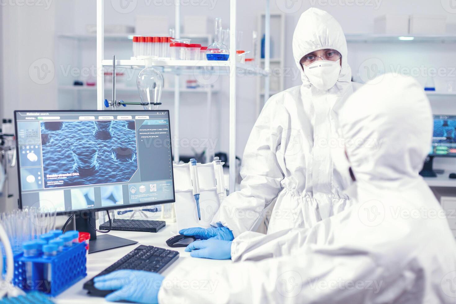 enfermeira dentro proteção terno discutindo com laboratório técnico vestido dentro equipe do médicos trabalhando com vários bactérias e tecido, farmacêutico pesquisa para antibióticos contra COVID-19. foto