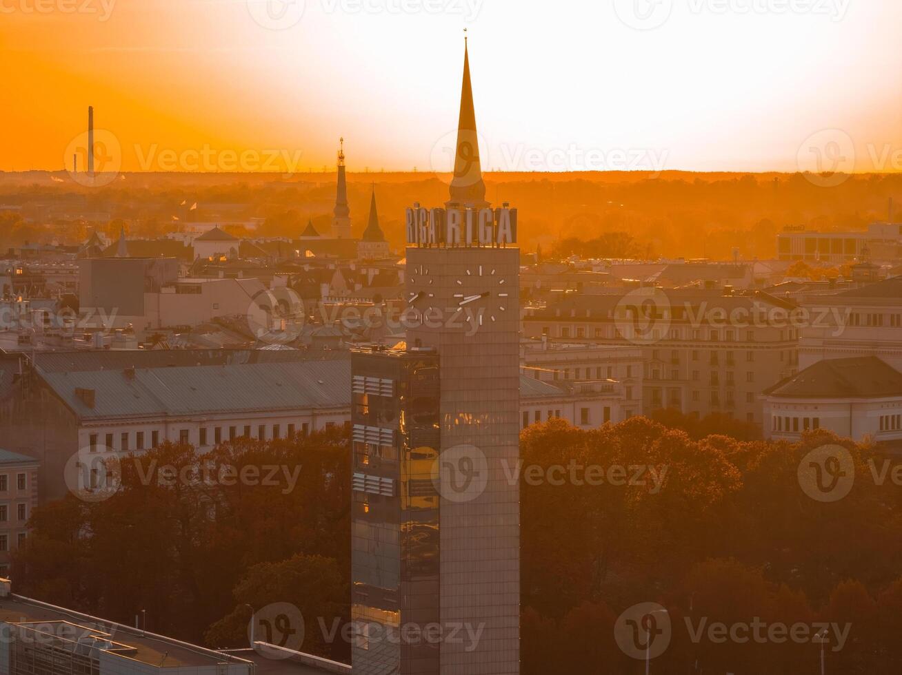 aéreo panorâmico pôr do sol sobre riga velho Cidade dentro Letônia. lindo Primavera pôr do sol sobre riga. riga relógio torre fechar acima Visão perto a trem estação. dourado hora fogo pôr do sol. foto