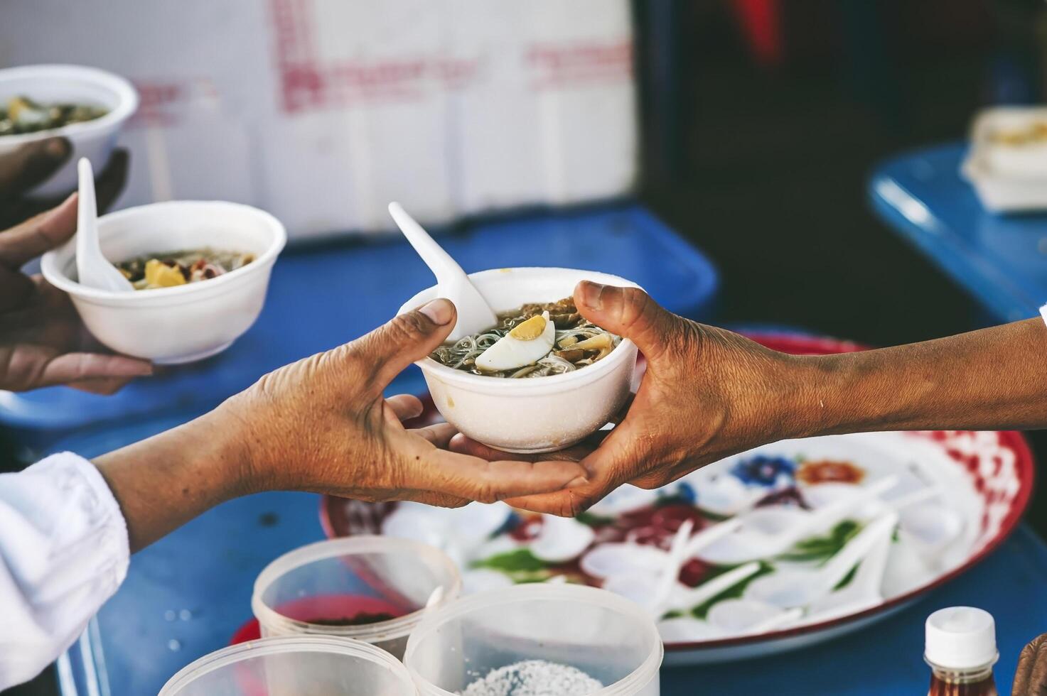 voluntários servindo quente refeições para com fome migrantes humanitário ajuda conceito. foto
