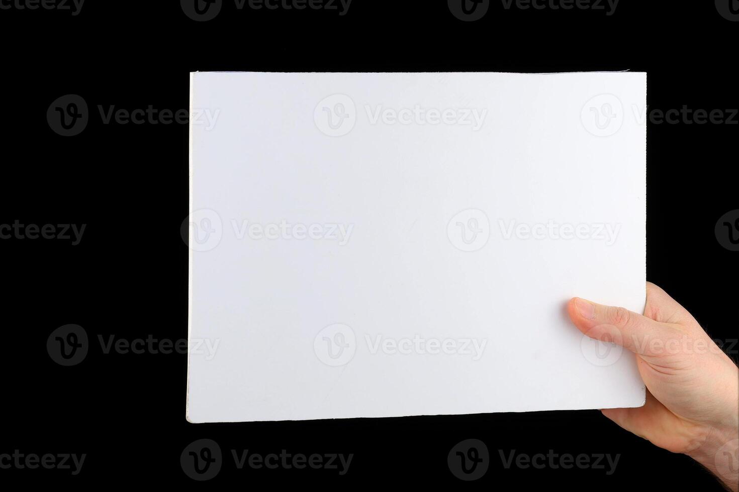 uma mão detém uma em branco Folha do papel. foto
