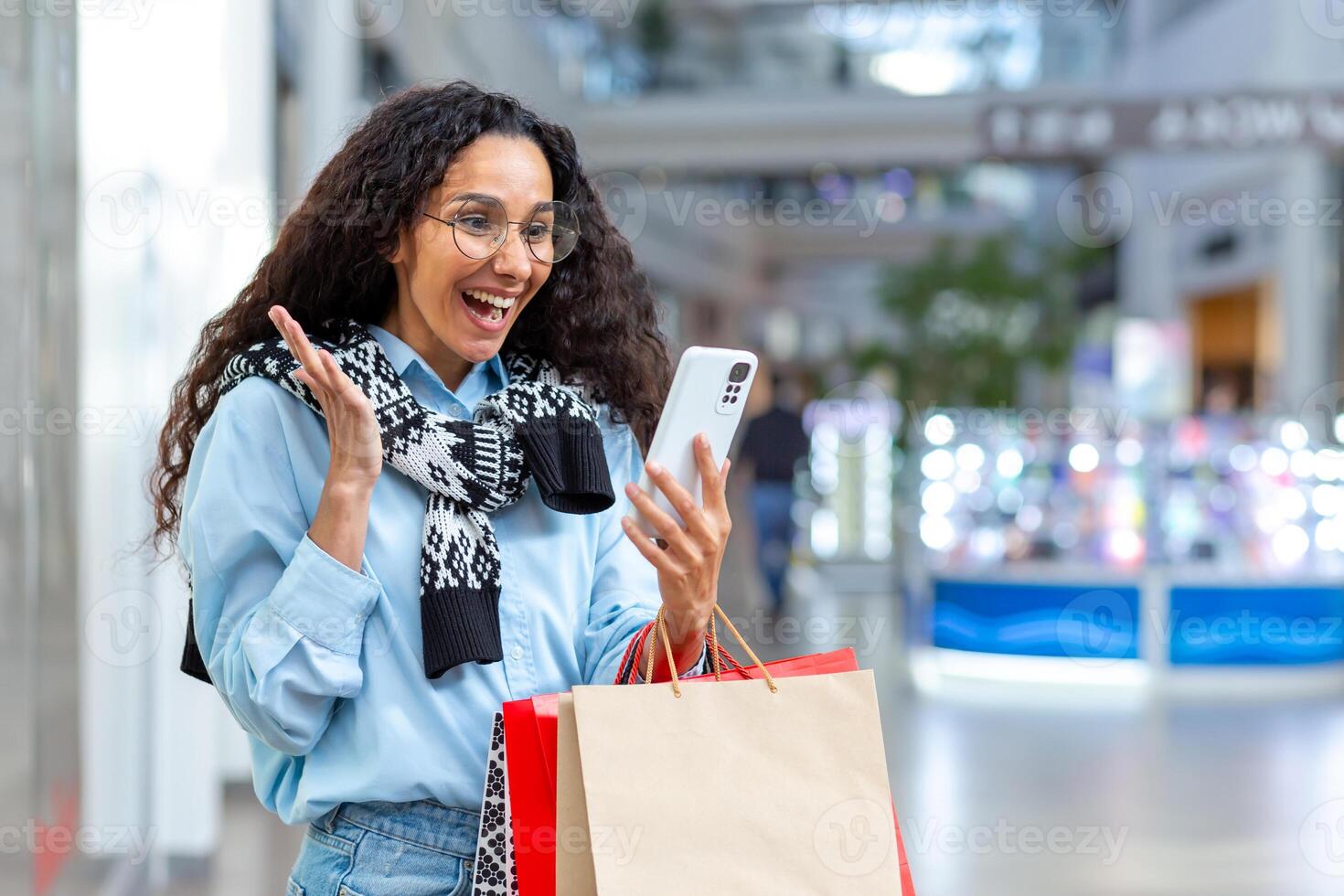 feliz fêmea comprador dentro loja falando em ligar com amigos, hispânico mulher usando Smartphone para conectados controlo remoto comunicação, partilha em formação sobre vendas e descontos foto