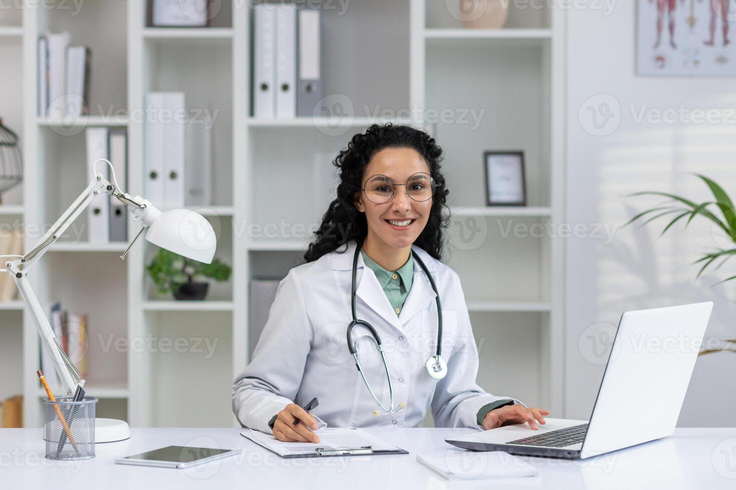 uma profissional hispânico fêmea médico com uma feliz sorriso, trabalhando dentro dela escritório, exalando calor e confiança. foto