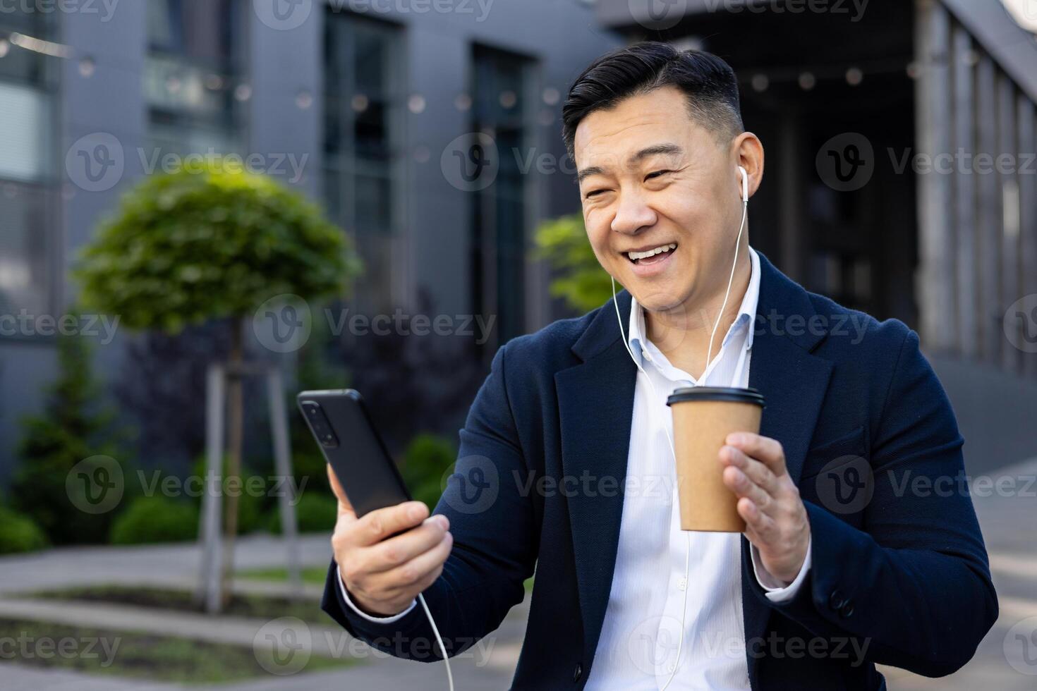 uma feliz masculino executivo dentro uma o negócio terno escuta para música em dele telefone durante uma relaxante café pausa. foto