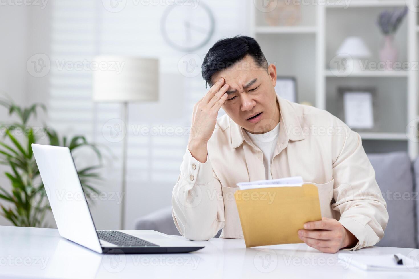 chateado e desapontado homem dentro casa escritório recebido mensagem enviar envelope com mau notícias, ásia homem trabalhando dentro casa escritório às escrivaninha com computador portátil. foto