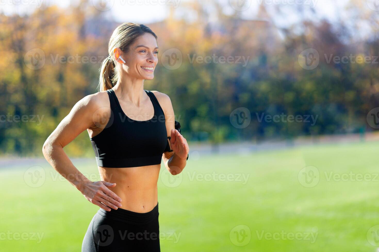 fêmea atleta é corrida dentro a estádio em uma ensolarado dia, mulher dentro roupa de esporte é ativo. foto